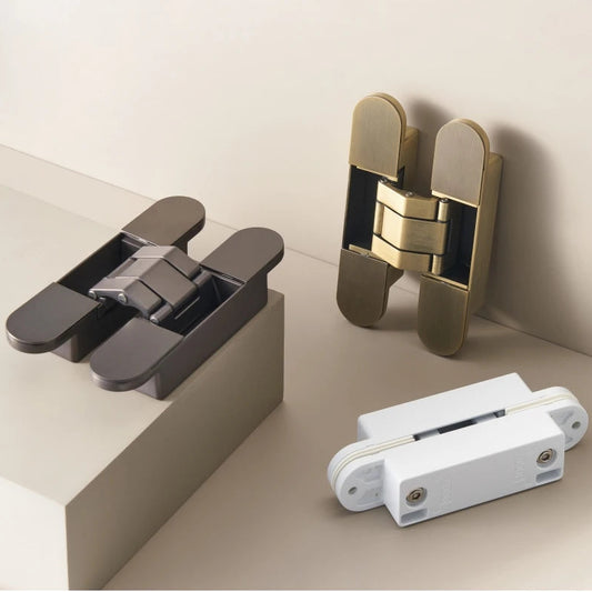 overzicht van 3 zogenaamde onzichtbare of inbouw deurscharnieren, uitgevoerd in brons, gun-metal en wit op een taupe ondergrond.
