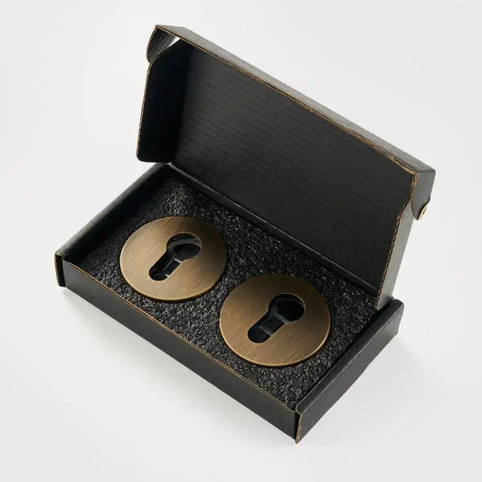 zwart doosje met daarin 1 paar ronde cilinder rozetten in de kleur brons