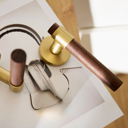 deurkruk van rond walnoot hout en mat messing op een rond rozet