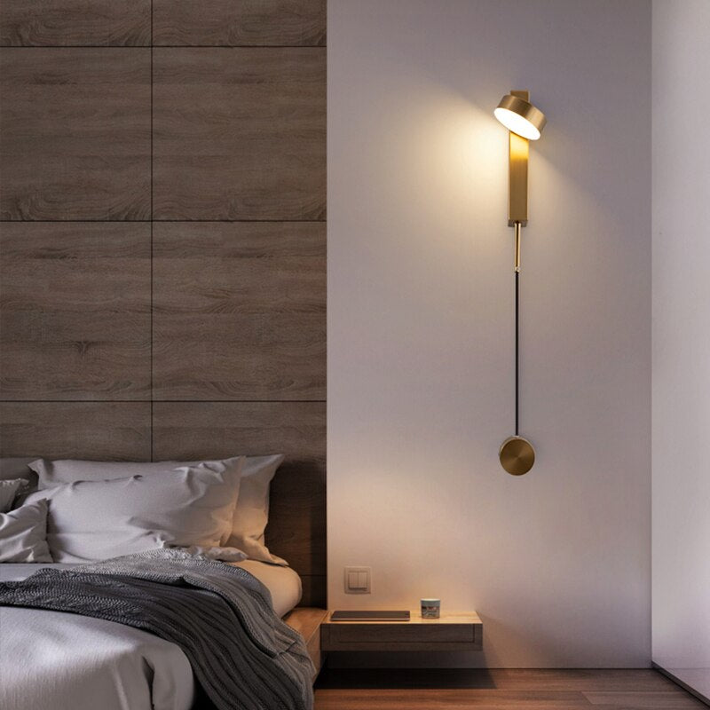 langwerpige dimbare wandlamp in messing met draaibare lamp in een slaapkamer naast een bed