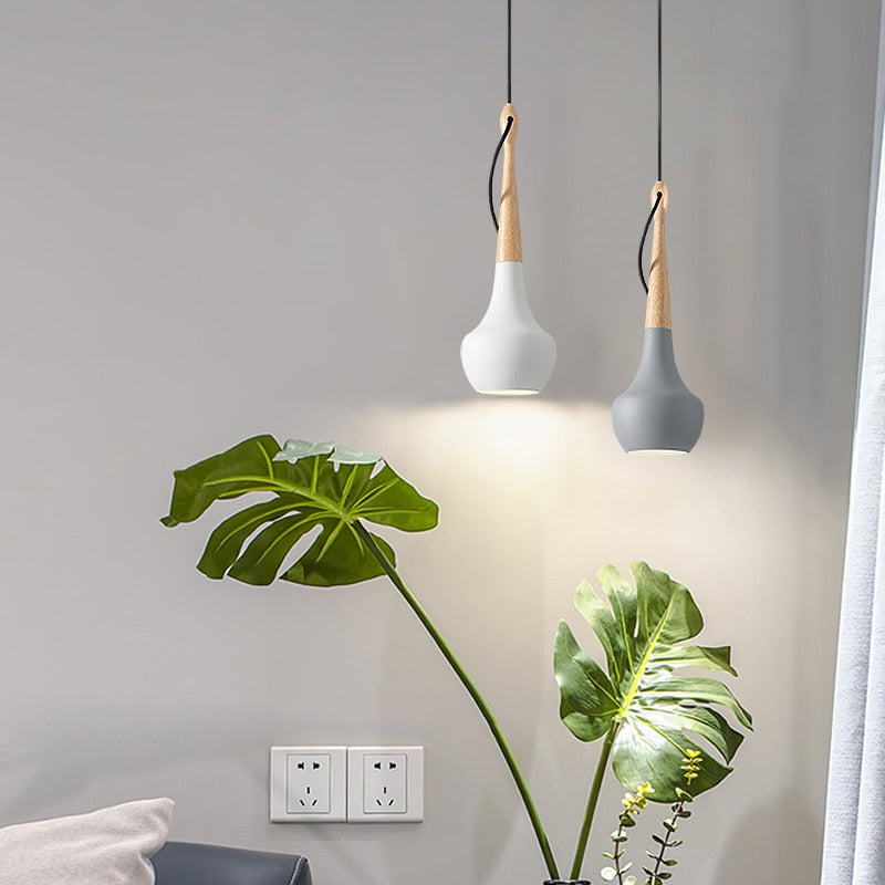 scandinavisch model hanglamp in een woonkamer, combinatie van grijs e wit aardewerk en hout 