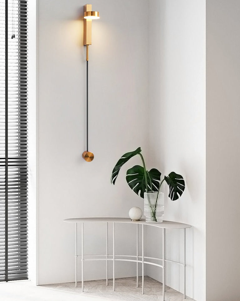 langwerpige dimbare wandlamp in messing met draaibare lamp op een witte wand in een woonkamer