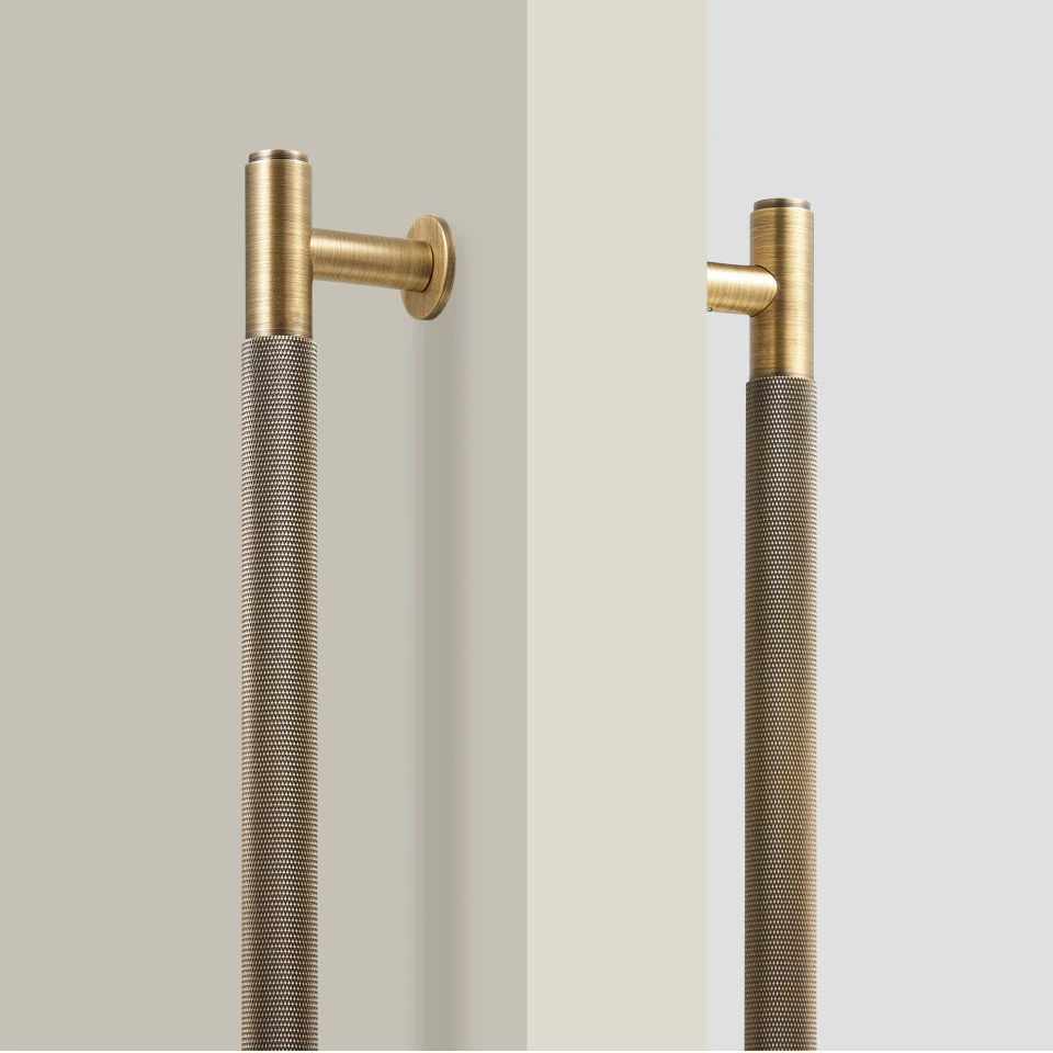 Gouden messing deurgreep met knurled textuur tegen witte achtergrond, industrieel design met gestructureerd oppervlak