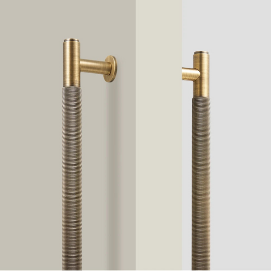 Gouden messing deurgreep met knurled textuur tegen witte achtergrond, industrieel design met gestructureerd oppervlak