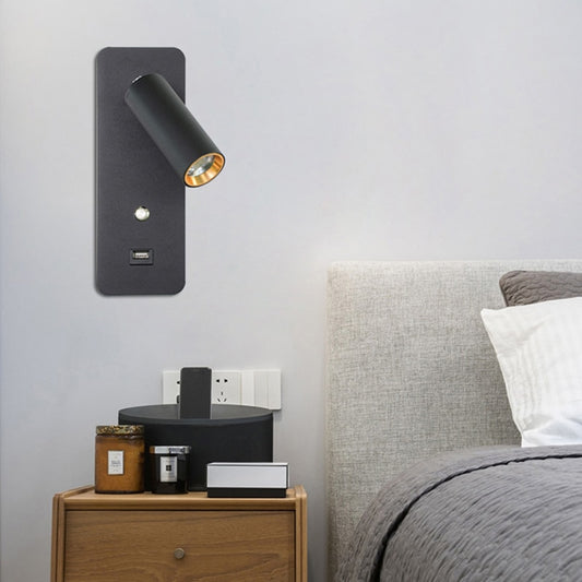 zwarte wandspot met usb aansluiting op een grijze wand naast het bed in de slaapkamer