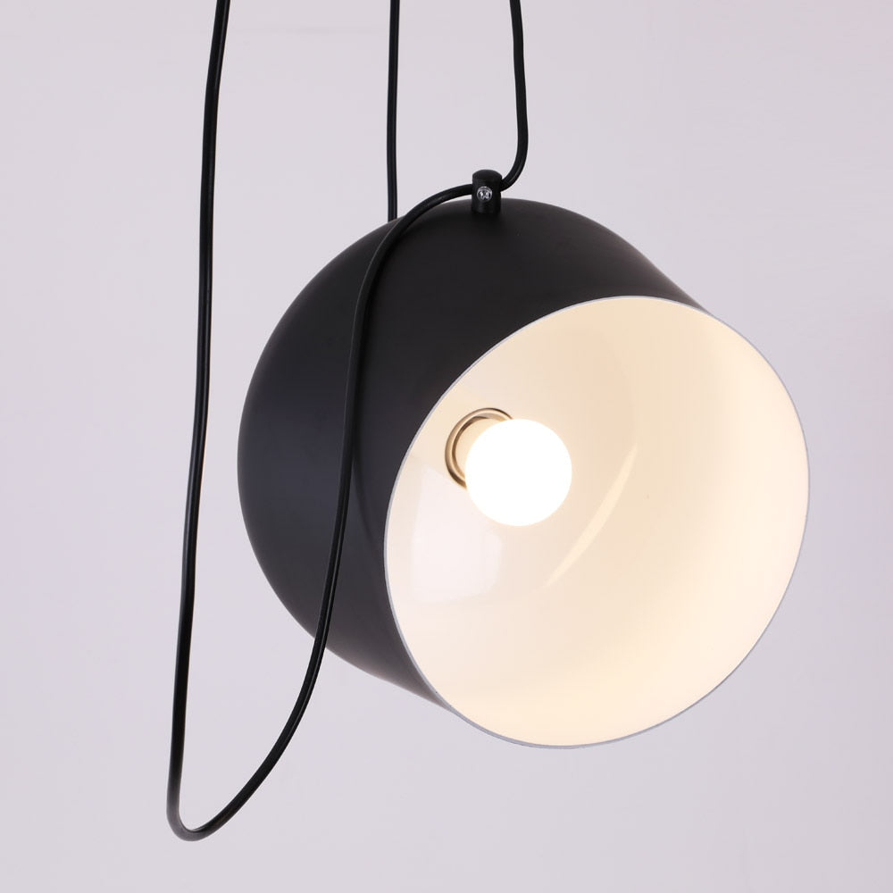 close up van een zwarte industriële design lamp met een witte binnenkant aan een zwart snoer