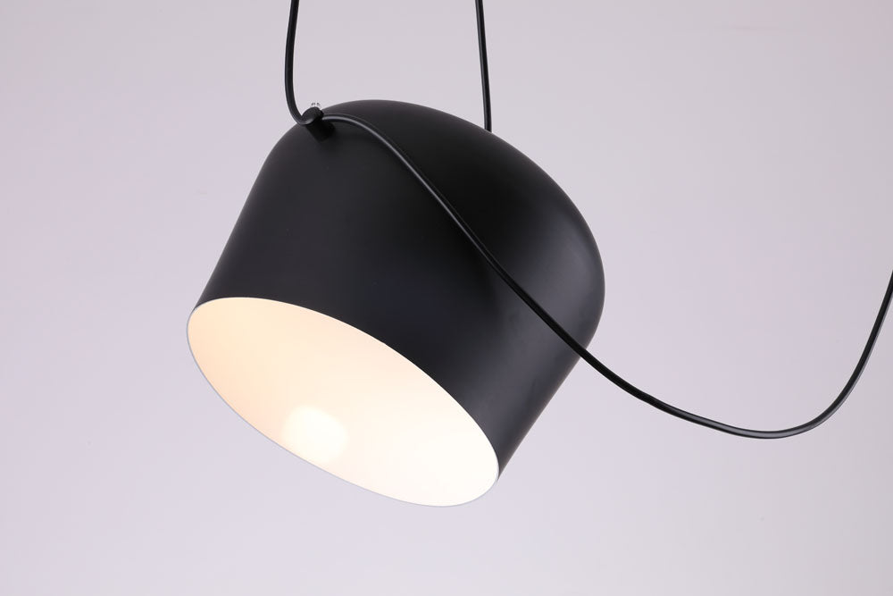 close up van een zwarte industriële design lamp met een witte binnenkant aan een zwart snoer