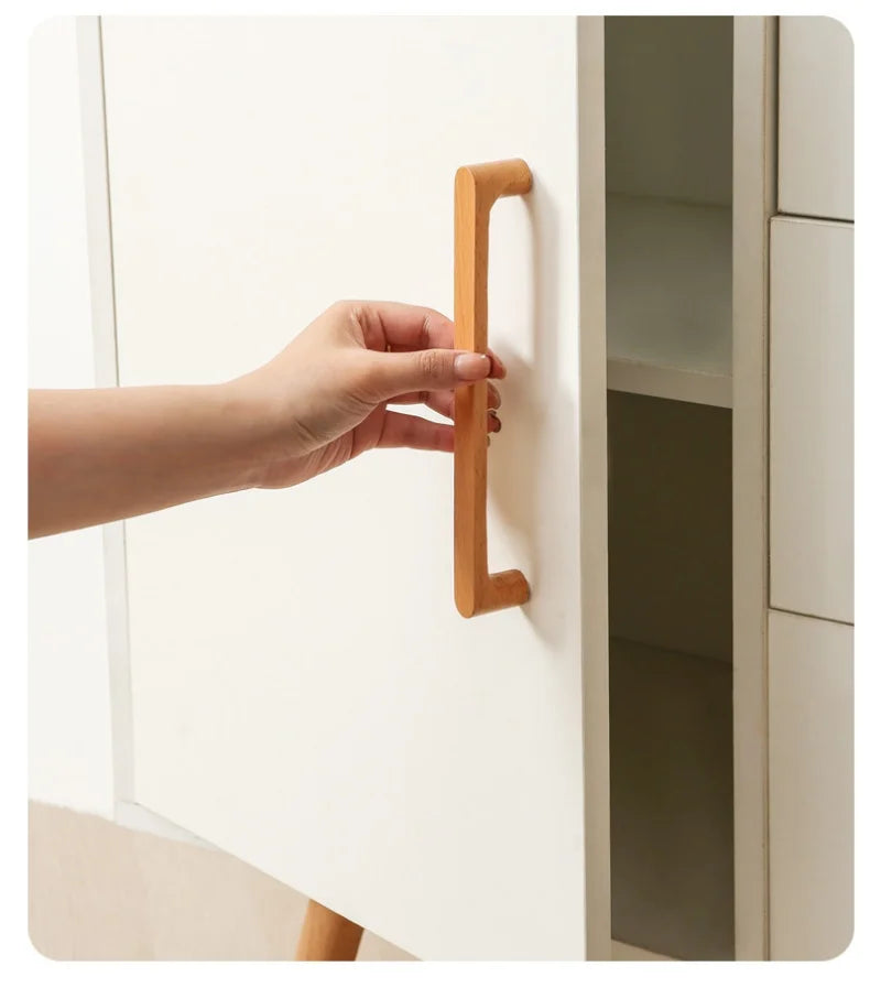 Houten meubelgreepje van berkenhout op een witte kast.