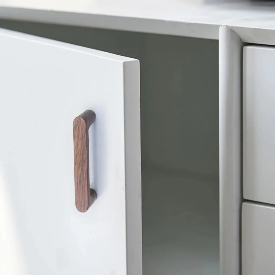 Houten meubelgreepje van Walnoothout op een witte kast.