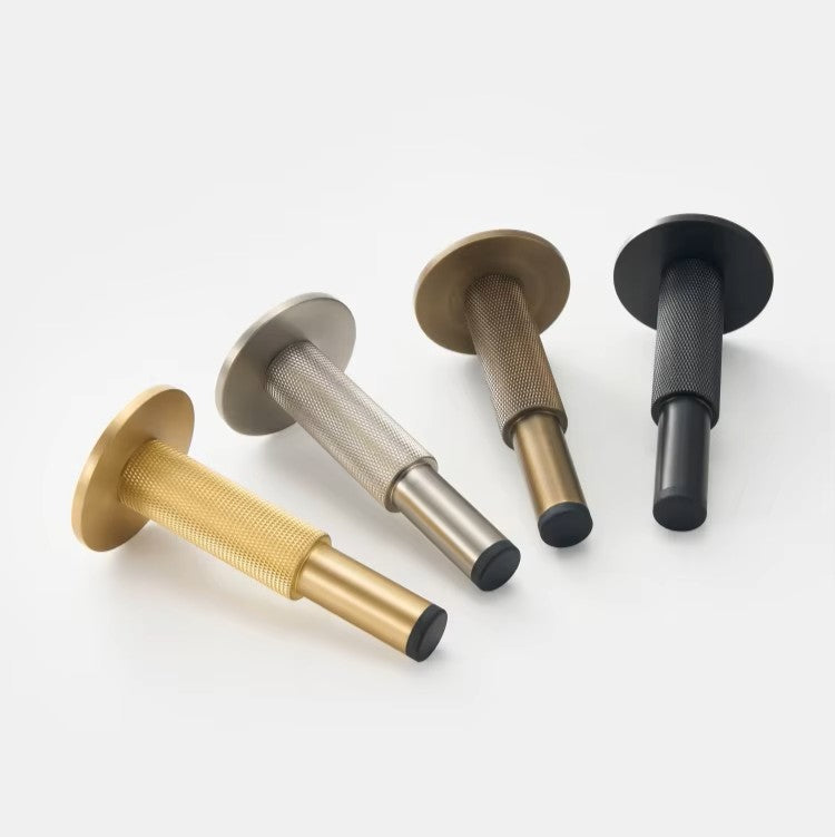 4 deurstops of deurbuffers met knurled motief liggend op een witte ondergrond