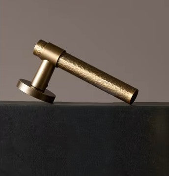 Gehamerde deurkruk scheef rechtop een zwarte ondergrond