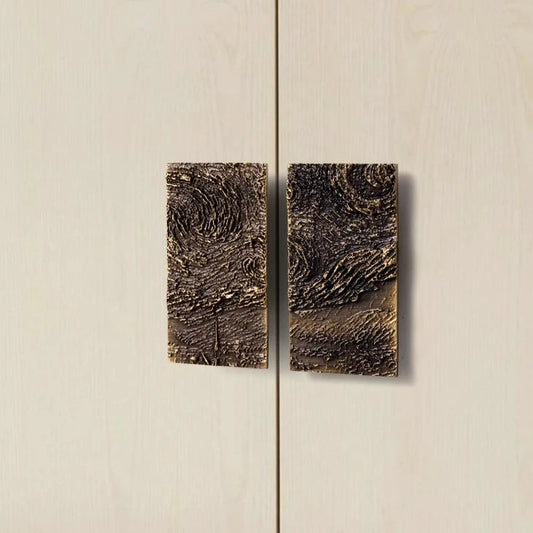 paar rechthoekige meubelgrepen in brons op een witte kast