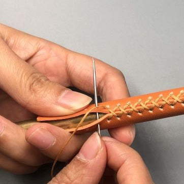 hand gestikt leer op een brons kleurige meubelgreep